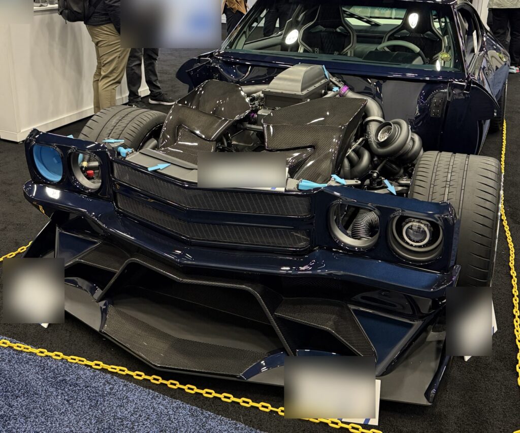 Large-format 3D printed car body parts on display at an industry trade show